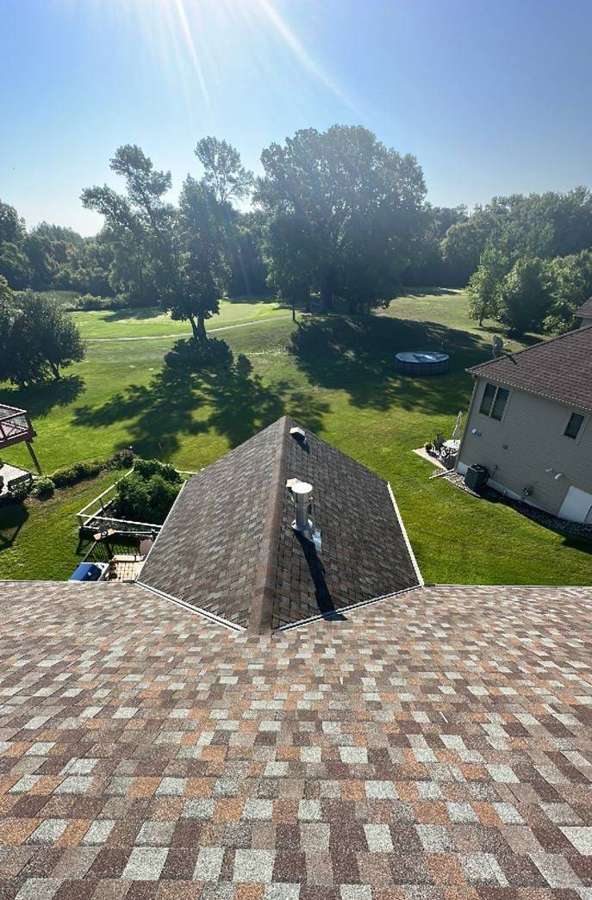 View down a multi-color shingle roof from the ridge of a home on Acacia Drive in Annandale, MN, July 2023