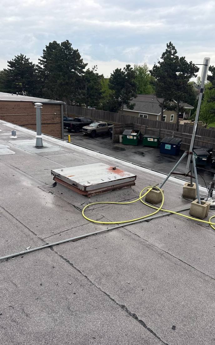 Rooftop view from a Hinsdale Dunkin' commercial roof inspection, overlooking the parking lot and nearby homes, April 2026