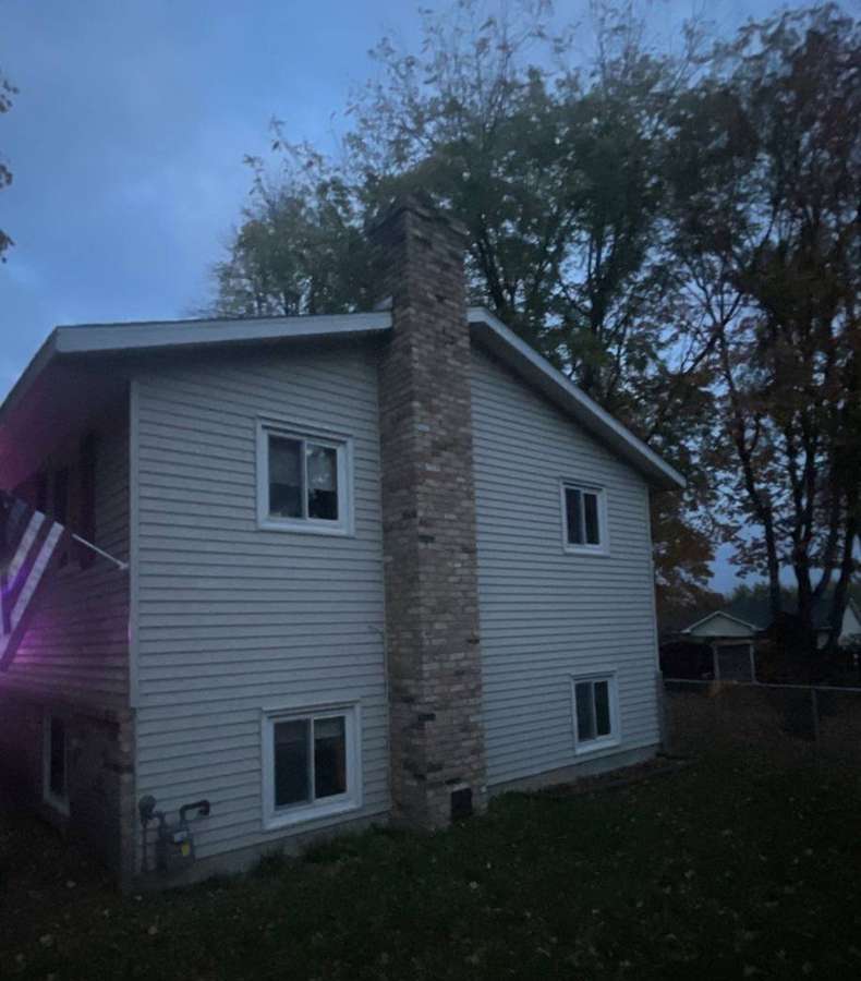 Two-story side of a Buffalo home photographed at dusk during a storm inspection, October 2021