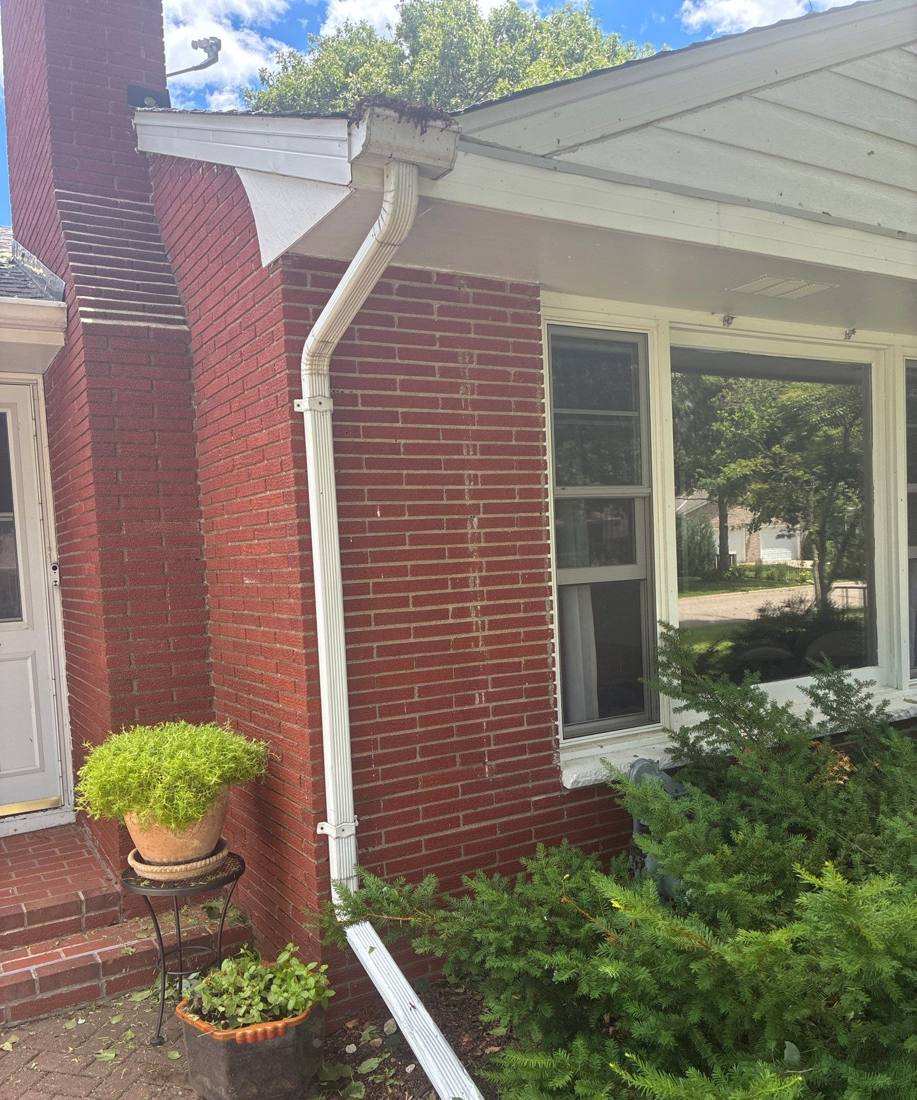 Chimney counterflashing and gutter detail on a Roseville brick home, June 2026
