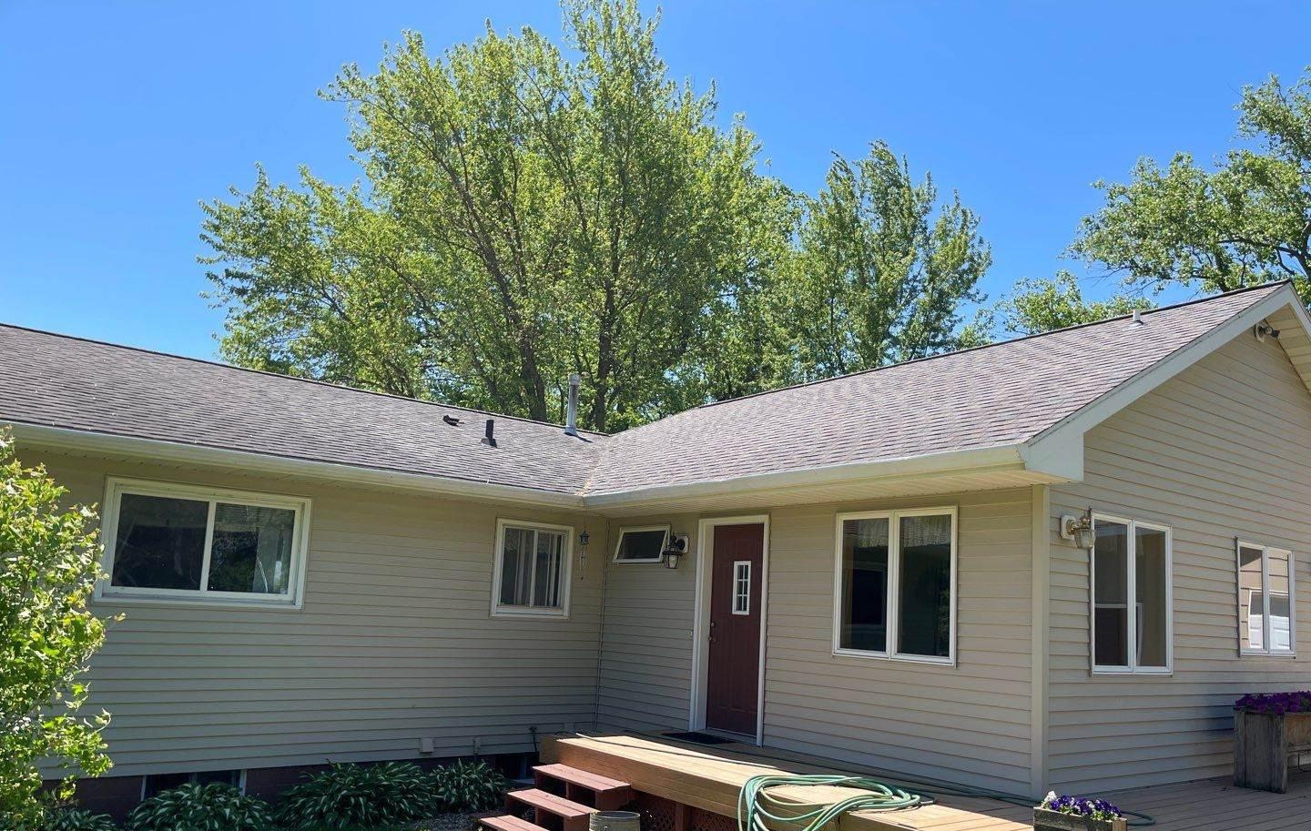 Ranch-style home in Pine Island, MN with a covered deck, photographed by Repair King during a roof inspection