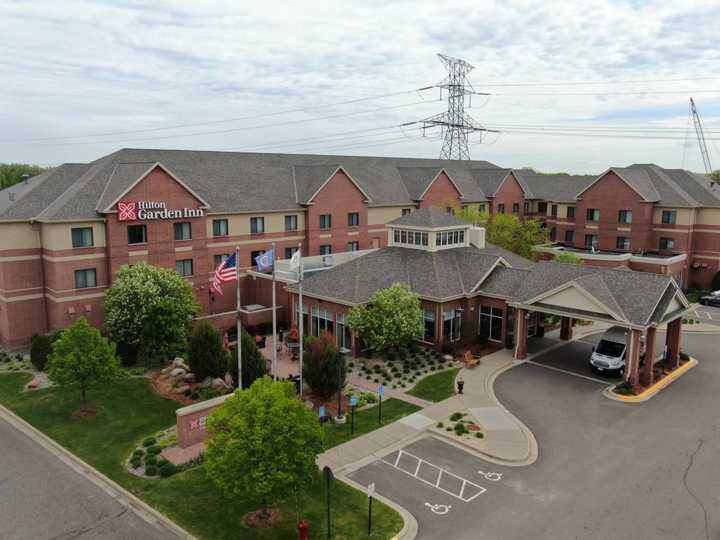 The Hilton Garden Inn in Maple Grove, MN, with its glass-walled pavilion lobby and shingle roof, photographed by Repair King's drone in May 2019