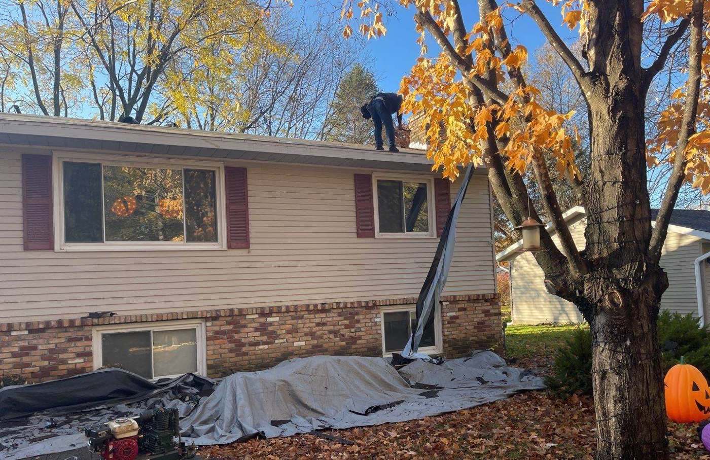 Repair King roofer tearing off shingles on a split-level home in Buffalo, MN, October 2021