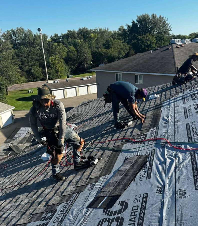 Repair King roofers installing underlayment on an apartment building roof in Hutchinson, MN, August 2024
