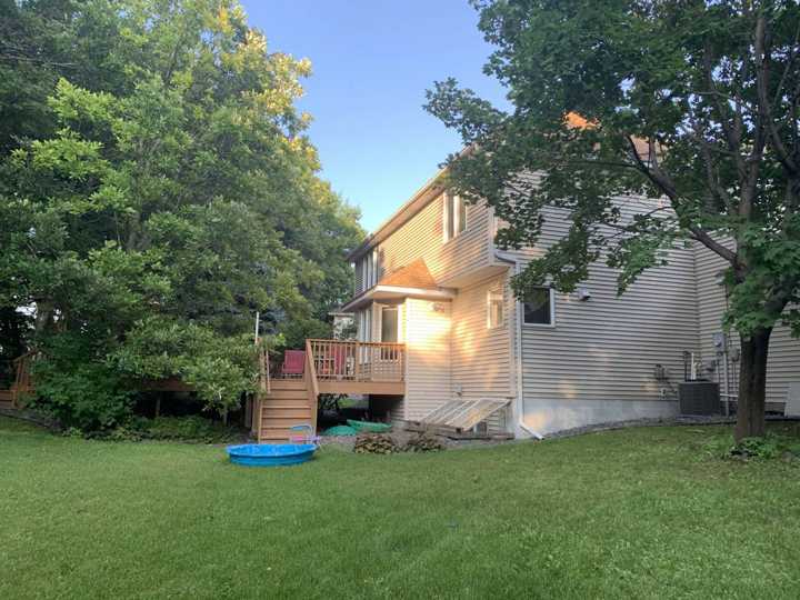 Back of a two-story Plymouth, MN home with a deck and mature trees, photographed during a Repair King inspection in August 2019