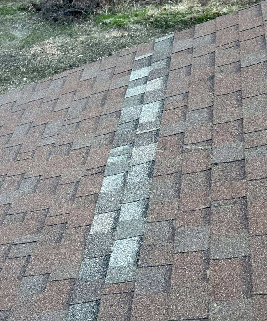 Chalk-marked hail hit on a shingle at Shoreline Commons, April 2024
