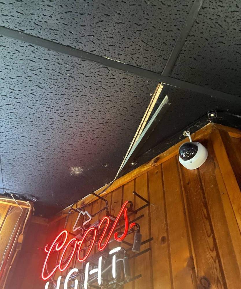 Inside Hoppers Bar & Grill in Waconia during a 2026 roof inspection, tracing a ceiling area back to the rooftop above