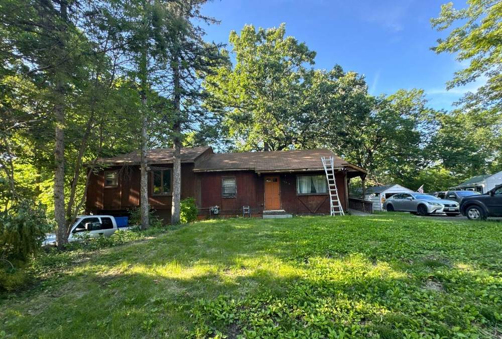 Cabin-style home in Minnetonka photographed during a roof inspection, June 2024