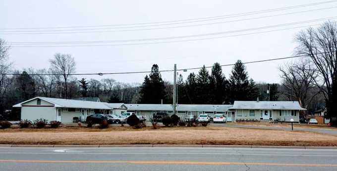 Red Rock Lodge's row of single-story motel buildings seen from across Hastings Avenue in Newport, MN, in winter
