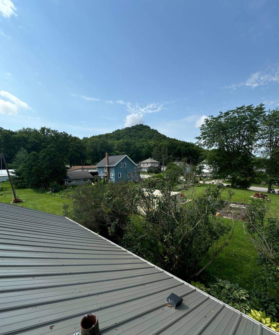 View across the valley from a standing-seam metal roof near Altura, July 2024