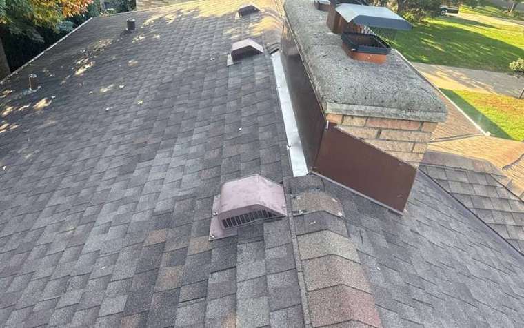 Shingle roof with brick chimney and brown metal chimney flashing on a Roseville home near Ryan Avenue, October 2025