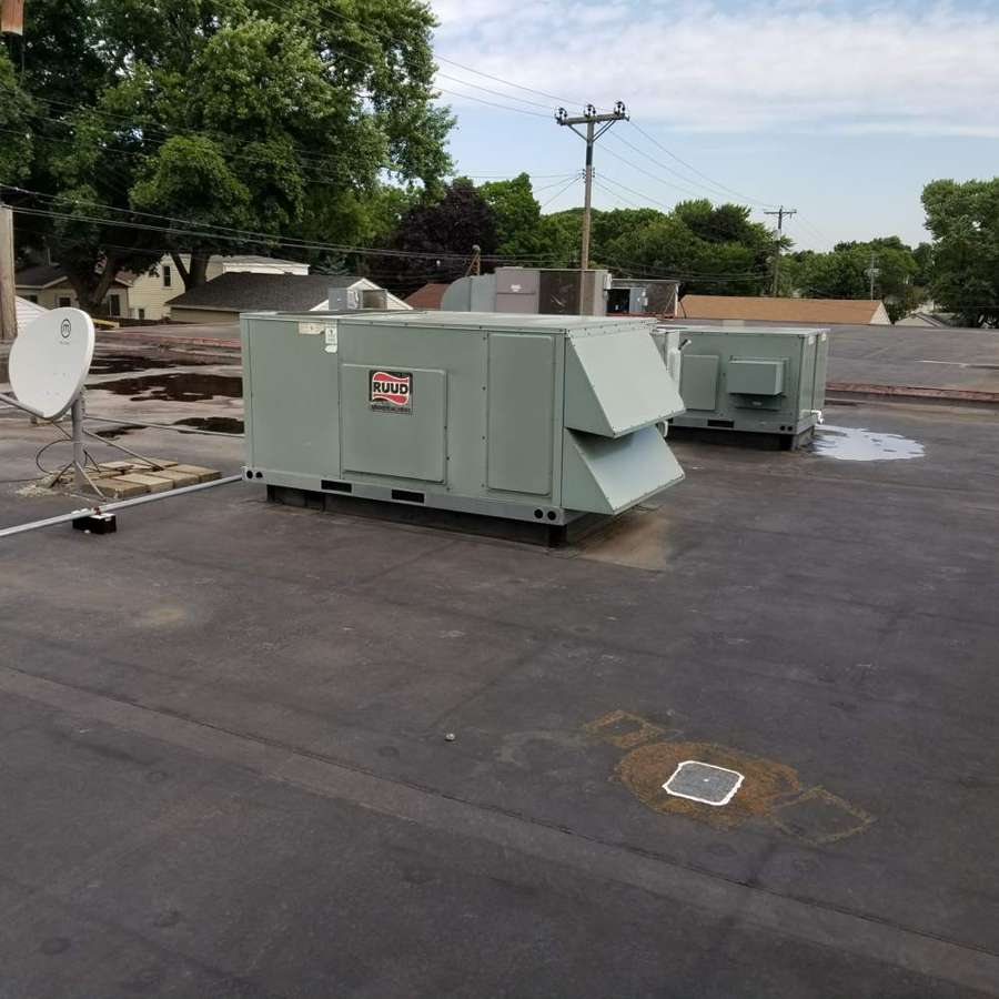 Flat EPDM roof over the Little Caesars strip center in West St. Paul, MN, with two rooftop HVAC units, a satellite dish and a roof drain