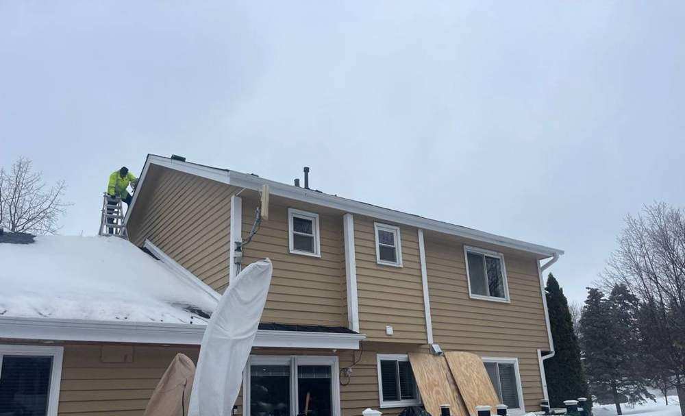 Repair King crew clearing an icy roof edge in Excelsior before a winter re-roof, February 2023