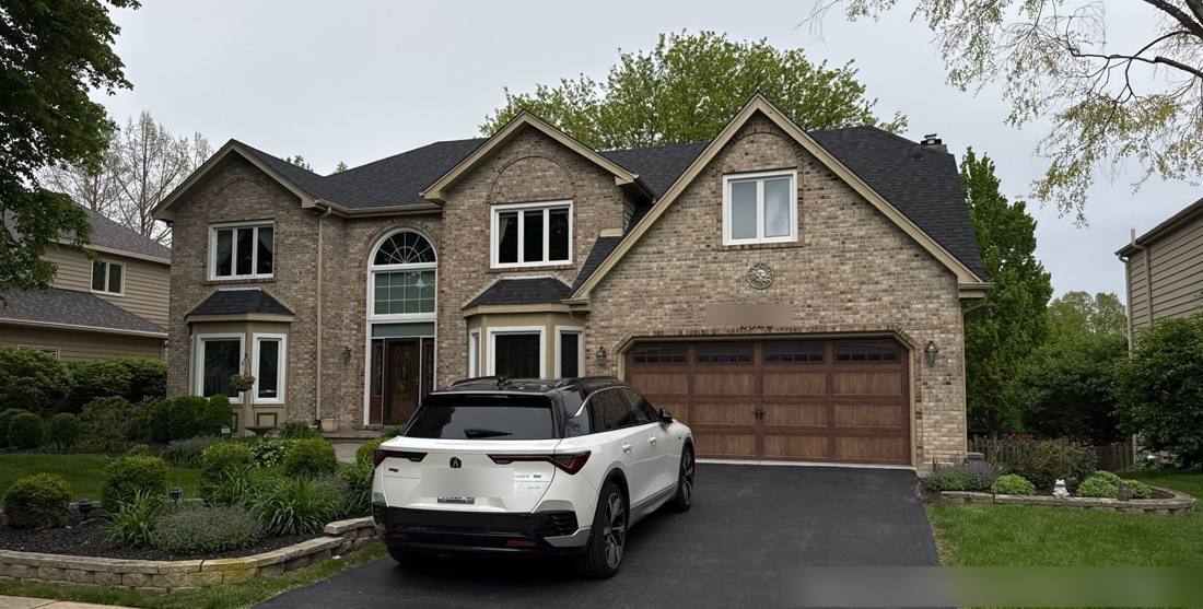 Two-story brick home in Naperville photographed during a roof inspection, May 2026