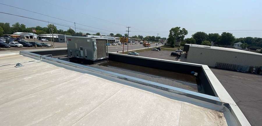 Low-slope roof, parapet and rooftop unit on the Dairy Queen in Cokato, MN, July 2023