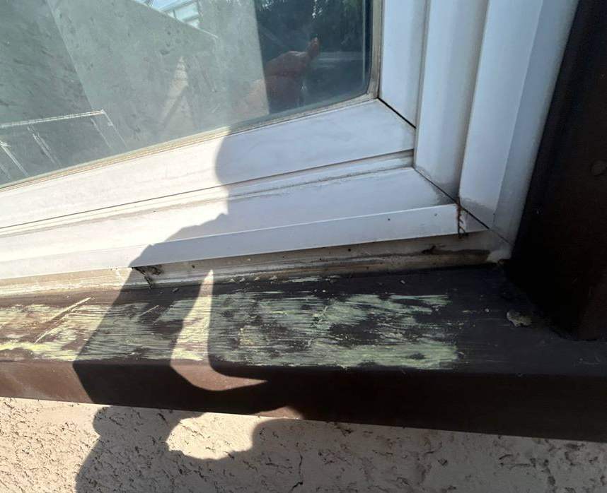 Chalk mark on a hail-dented metal window wrap on a St. Cloud home, September 2025