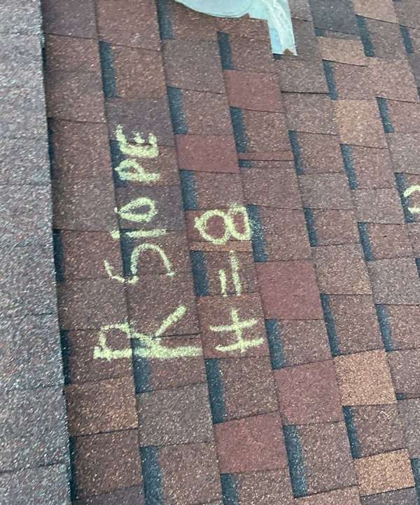 Chalked hail count 'R slope H=8' on a split-level roof on McKnight Road in Maplewood, MN, May 2023