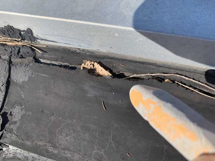 Split rubber membrane and debris at the metal roof edge at Washington Place in St. Cloud, MN, September 2019