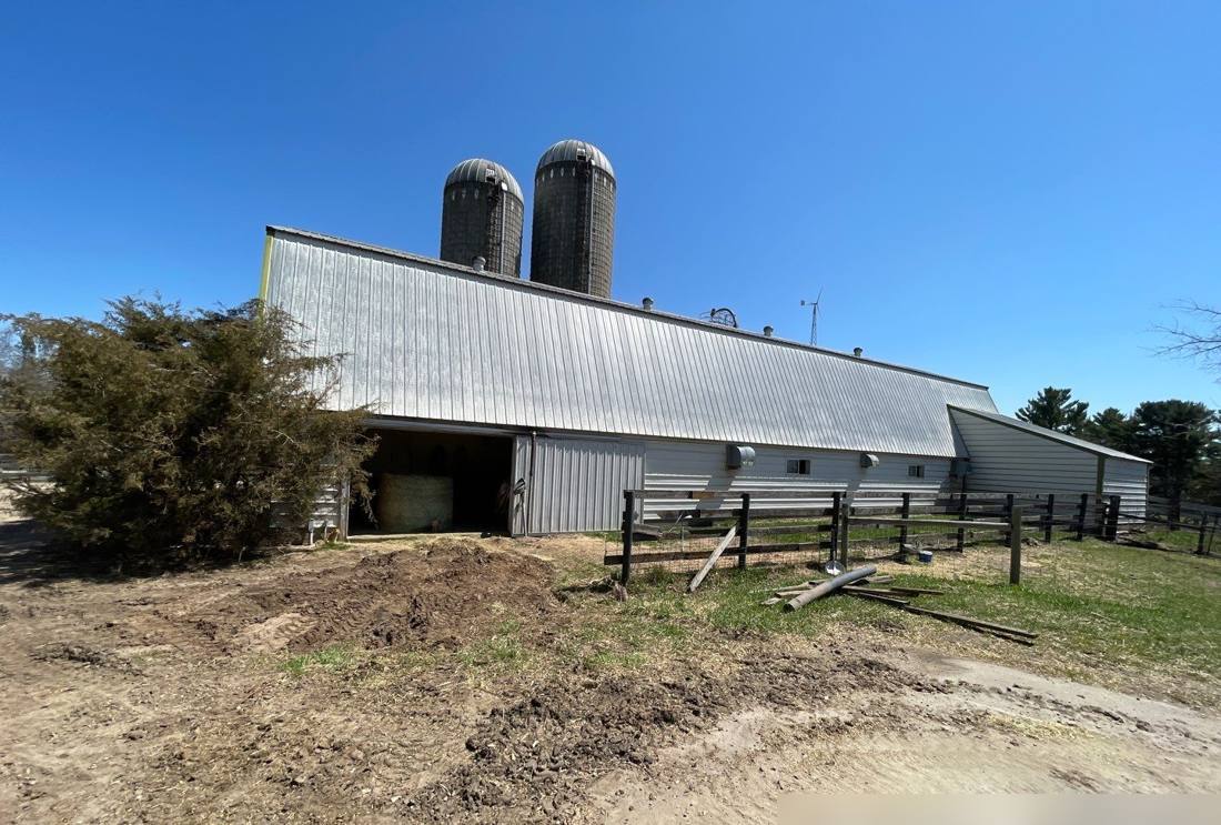 Dairy barn with two silos on a farm near Royalton, photographed during a roof inspection, May 2022
