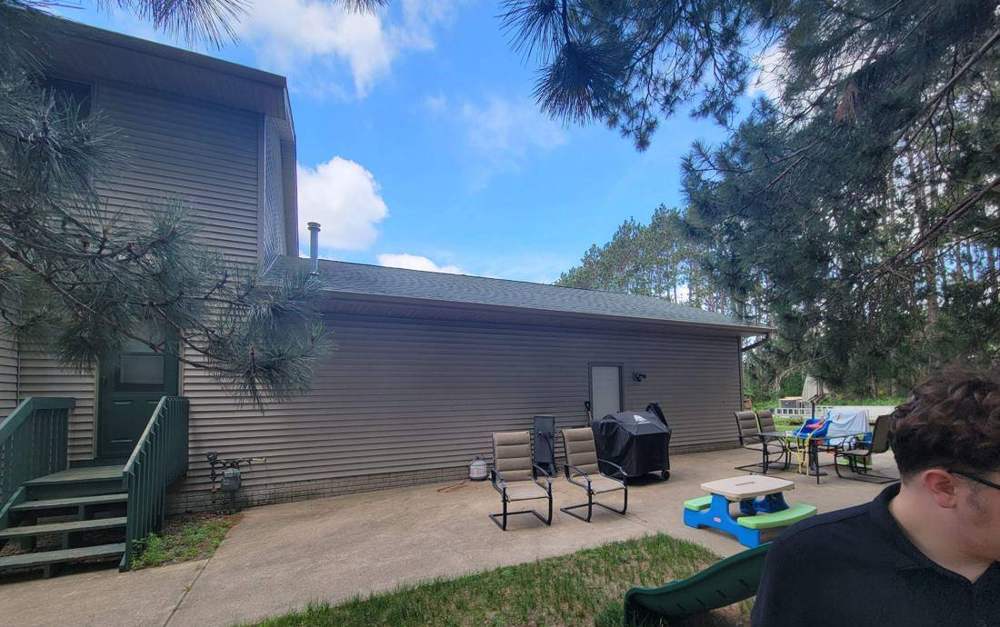 Rear patio and stairwell of a multi-entry Big Lake property photographed during a roof inspection, July 2022