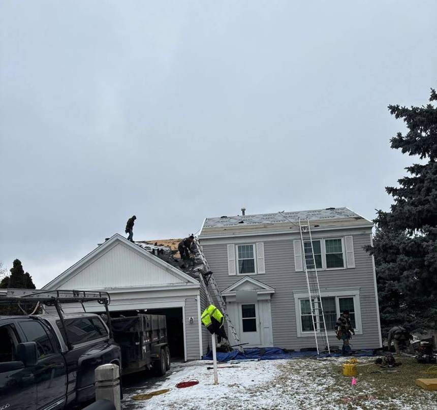 Repair King crew tearing off a two-story home's roof in the snow off Crestview Drive in Maplewood, MN, January 2024