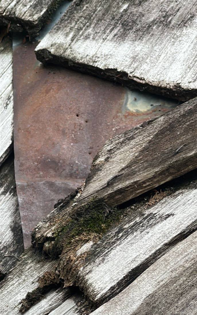Rusted-through valley flashing found under cedar shakes during a Hopkins roof inspection, August 2023