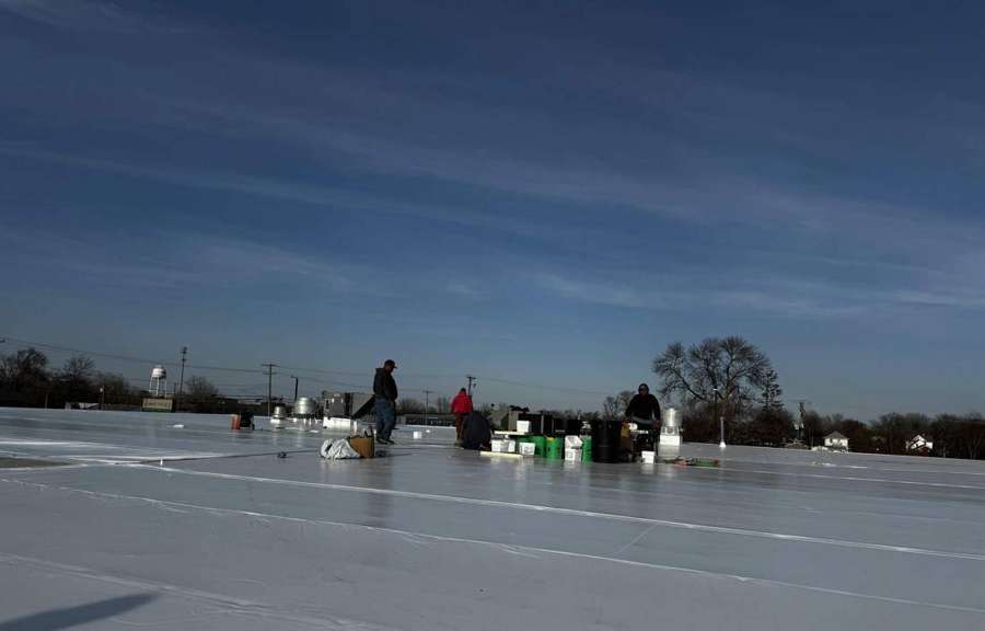 Repair King crew working on the low-slope roof of The Marketplace grocery store in Cokato, MN, April 2024
