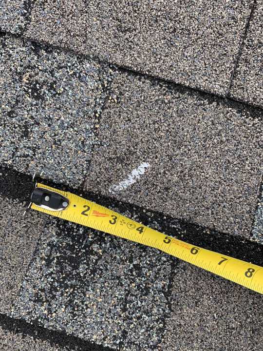 Chalk-circled hail hit on a shingle, measured with a tape, on the Hilton Garden Inn roof in Maple Grove, MN, May 2019
