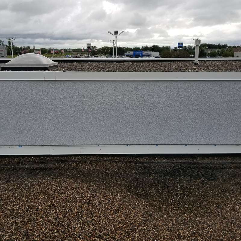 The old gravel roof along a parapet wall at Forest Lake Chrysler Jeep Dodge before the replacement