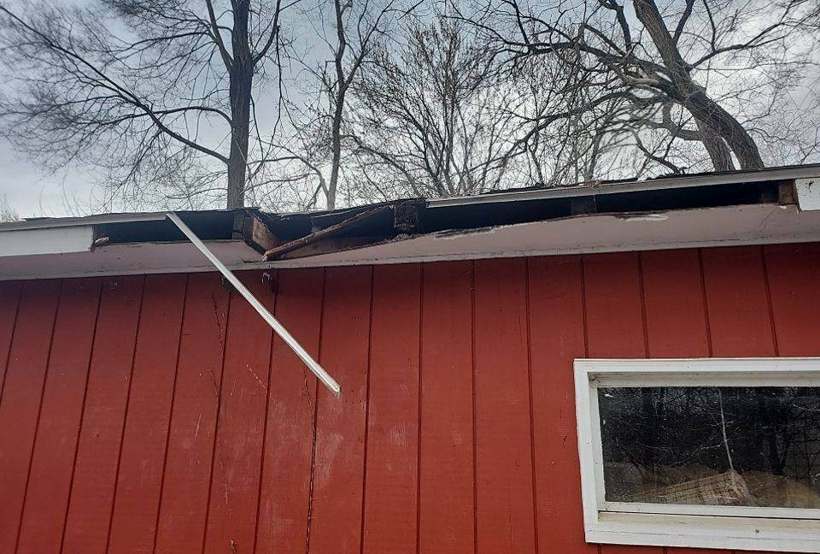 Broken roof edge and fascia along the side of a red-sided detached garage in Richfield, MN, documented by Repair King in April 2023