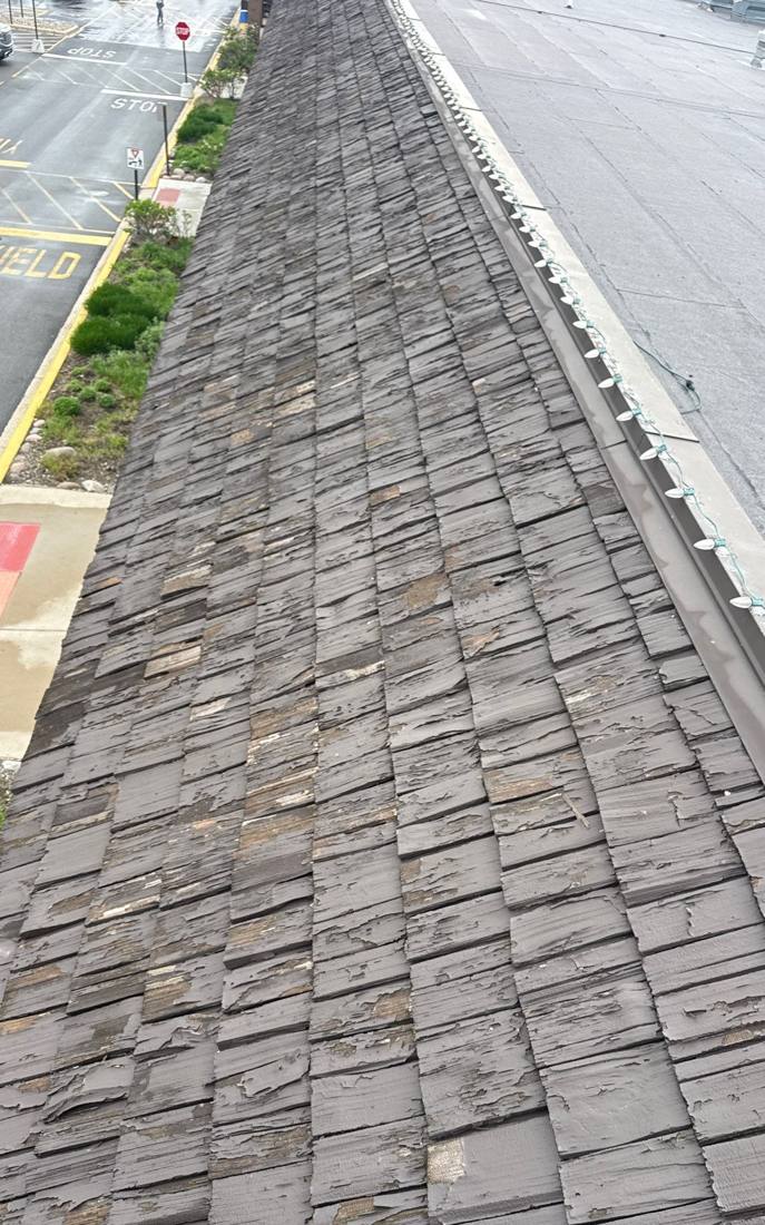 Weathered wood-look mansard fascia inspected on a Hinsdale commercial building, April 2026