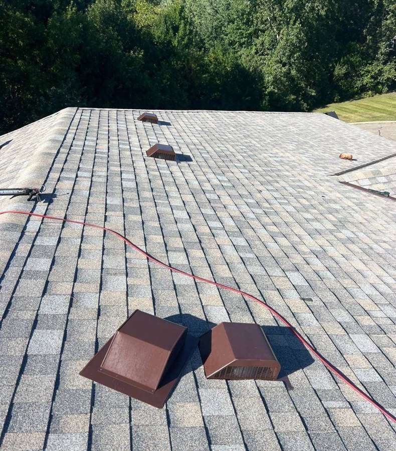 New shingles and roof vents going on an apartment roof in Hutchinson, August 2024