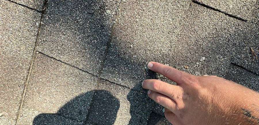 Creased shingle tab found during a July 2023 roof inspection in Annandale