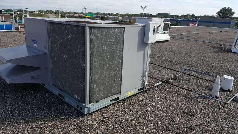 A rooftop HVAC unit sitting on the old gravel roof at the Forest Lake dealership