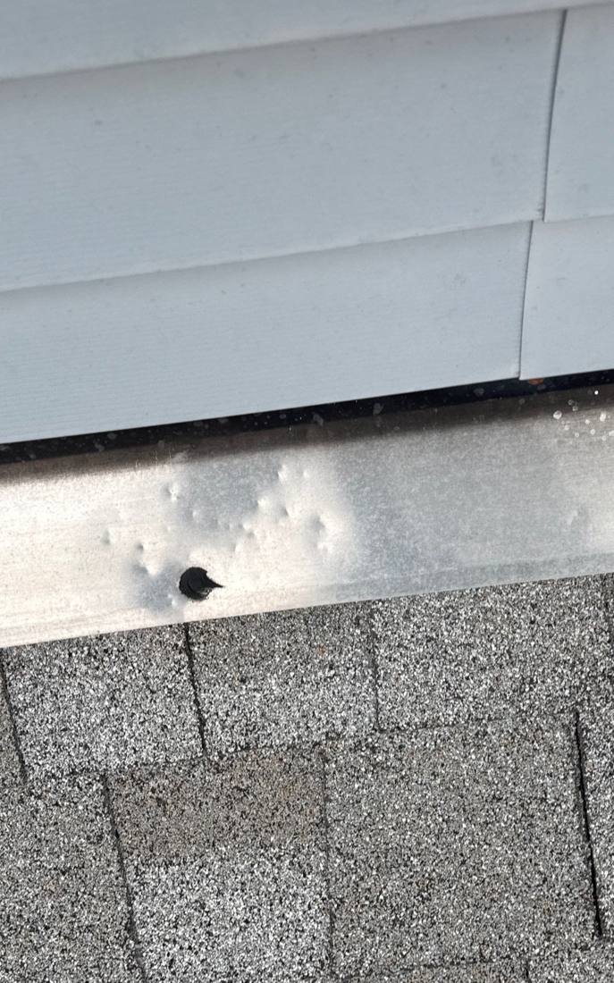 Hail dents in a gutter apron on a Plainfield home, April 2026