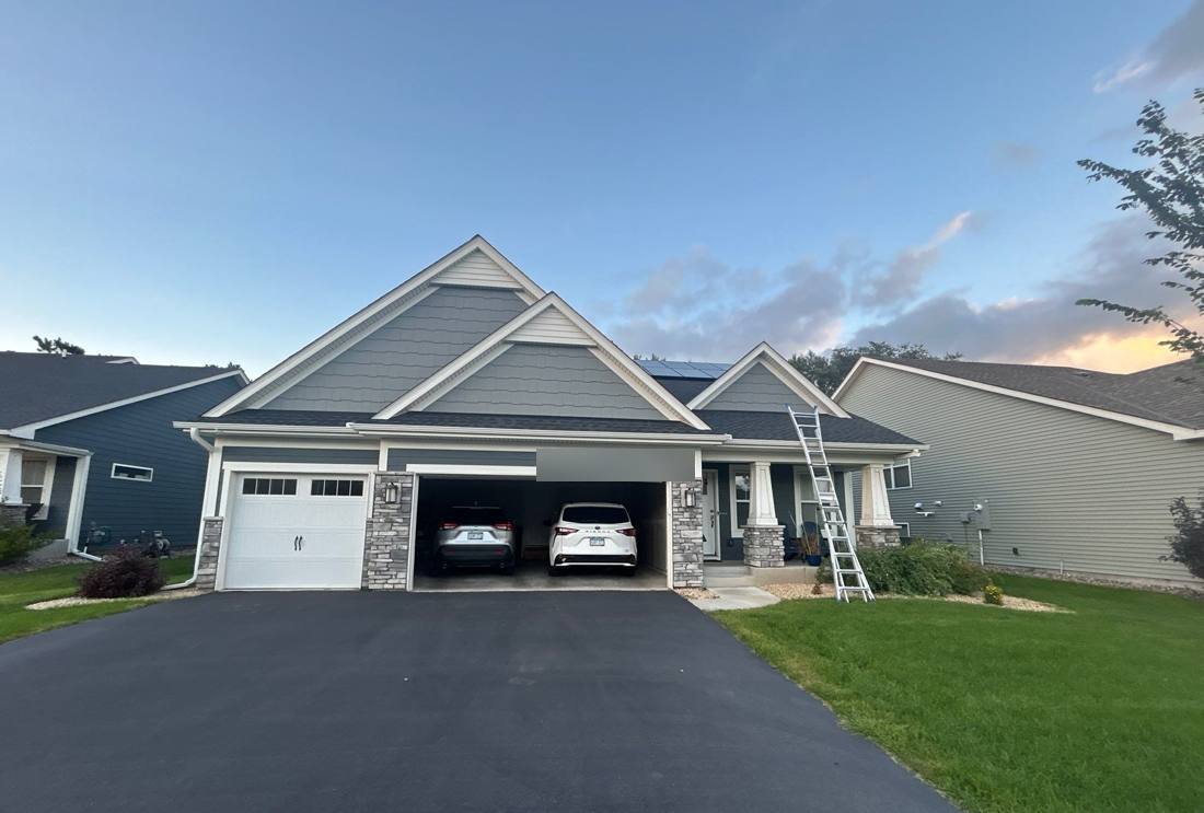 Twilight exterior of a three-car-garage Cottage Grove home after a Repair King roof project, September 2025