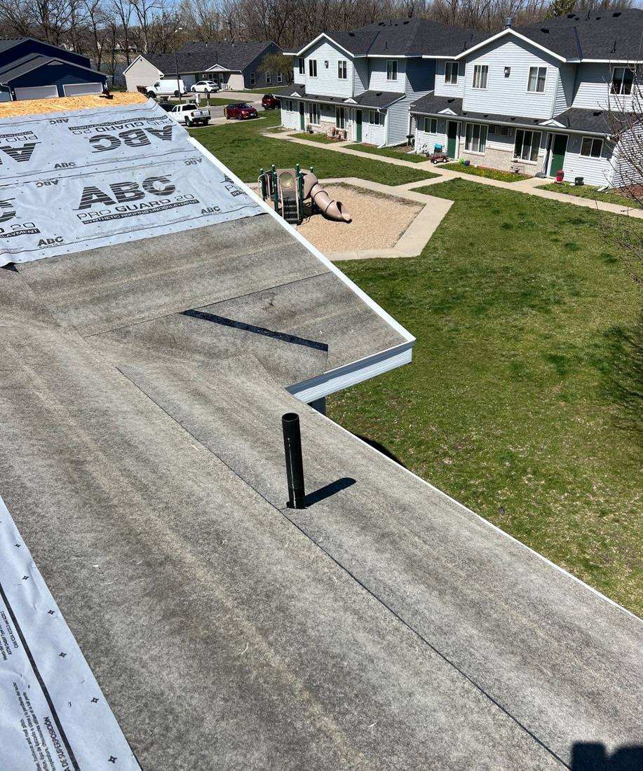 Underlayment going down on a Waters Edge building, with the shared playground below, April 2024