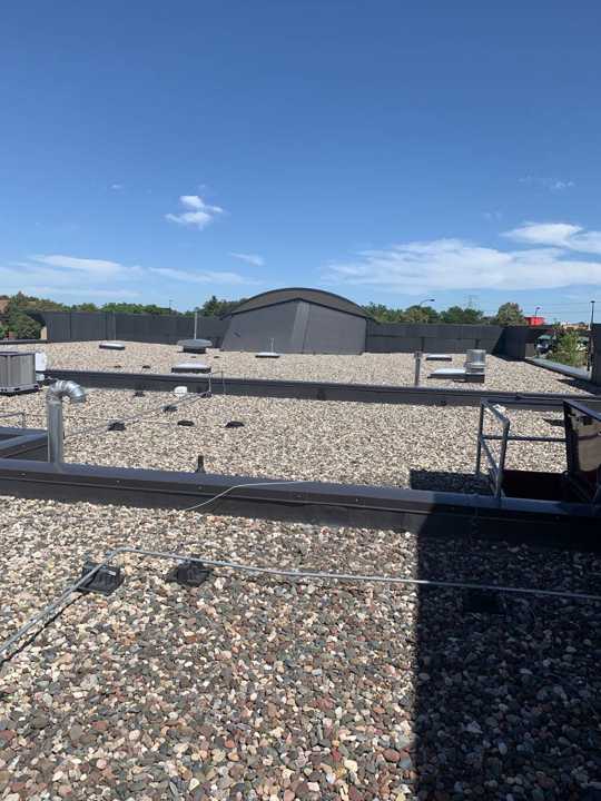 Ballasted rubber roof with the curved roof feature in the background at Paradise Car Wash in Maple Grove, MN, August 2019