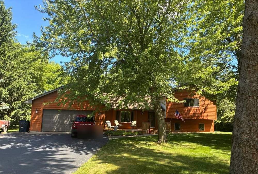Home on a wooded Chisago City lot photographed during a roof inspection, June 2026
