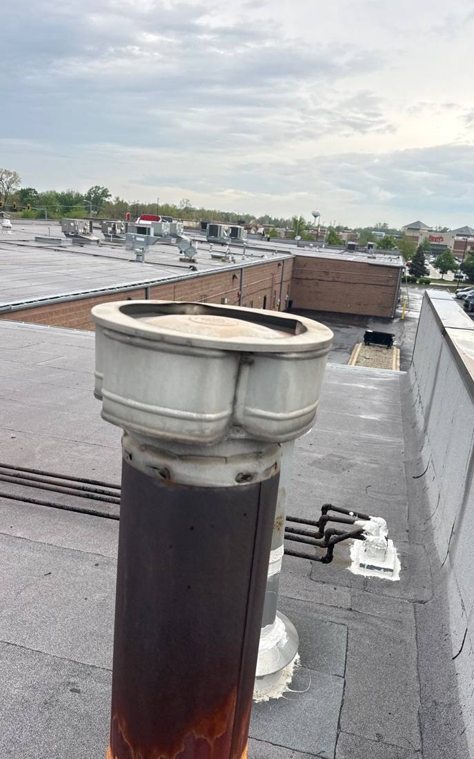Rusted pitch pot on a Hinsdale commercial roof, checked for leaks, April 2026