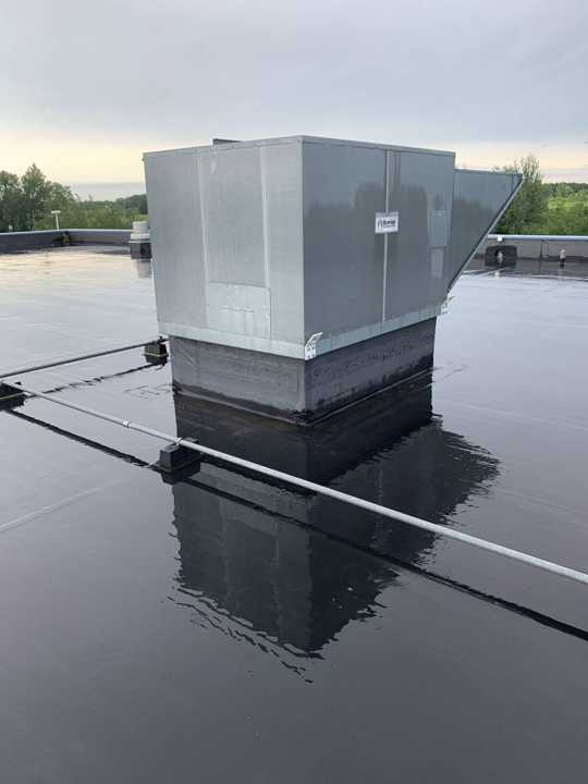 A rooftop unit standing in water on the Eide Chrysler flat roof in Pine City, July 2019