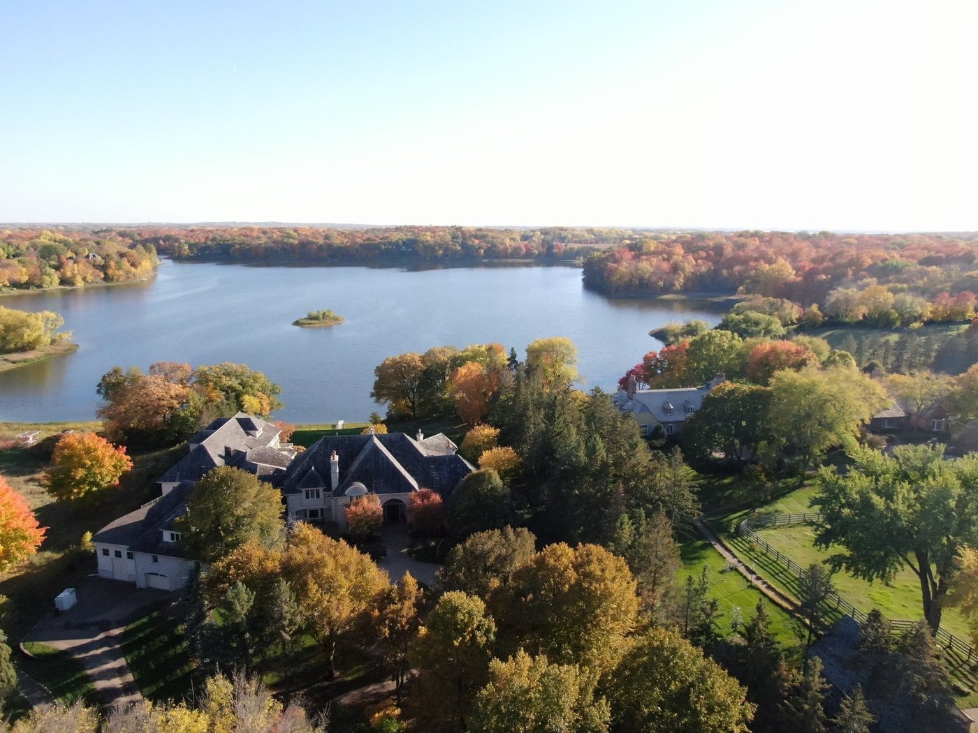 Drone aerial of a Lake Minnetonka estate with a cedar shake roof in fall color, documented by Repair King in October 2023