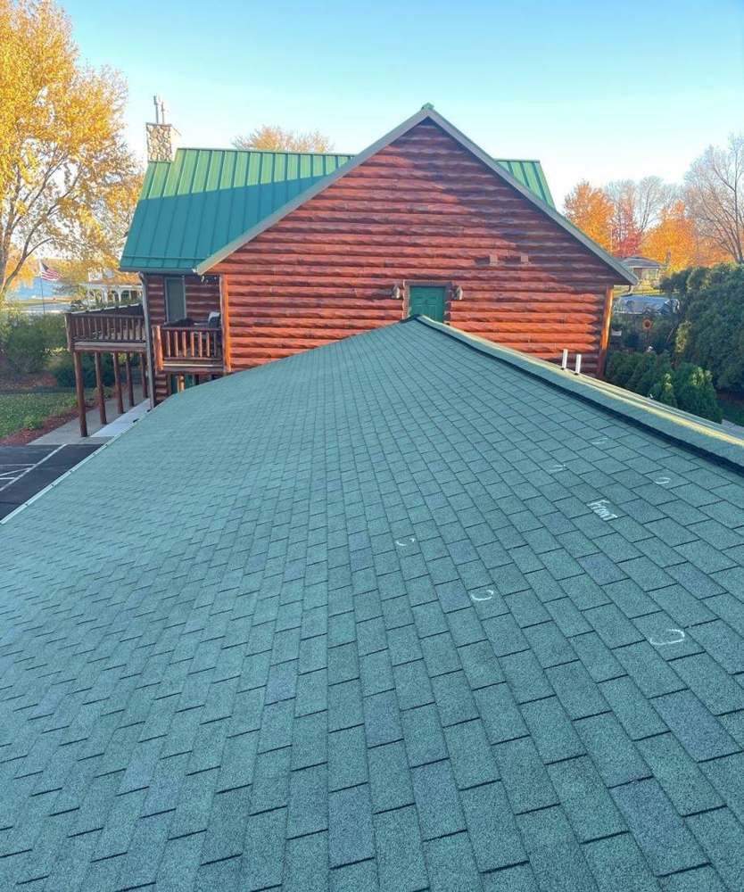 Green shingle roof with chalk-circled marks in front of a log-sided building at John Hall's Alaska and Guest Suites in Lake City, MN, October 2021