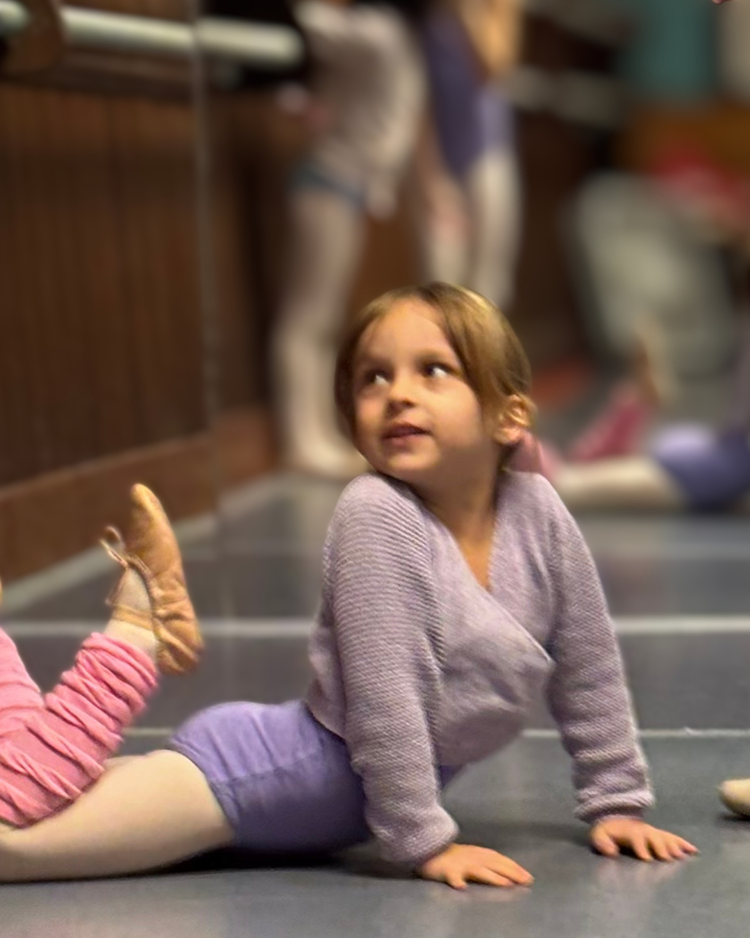 Young dancer stretching on the studio floor at Prince William Dance Academy in Nokesville, VA.