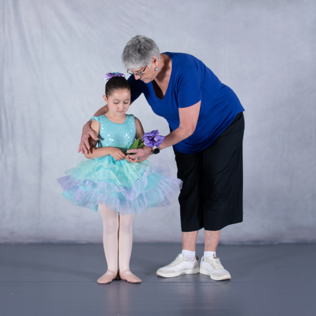 Ms. Kim, studio owner of Prince William Dance Academy, posing student on picture day as they prepare for recital