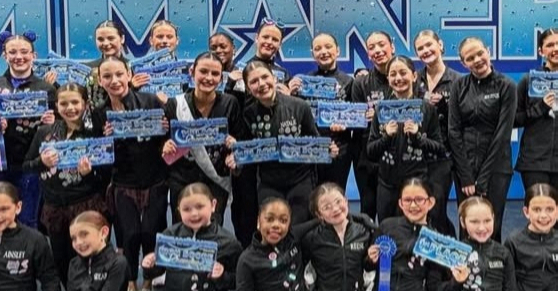 PWDA Company competitive dance team posing together in matching pink and black costumes at Prince William Dance Academy.
