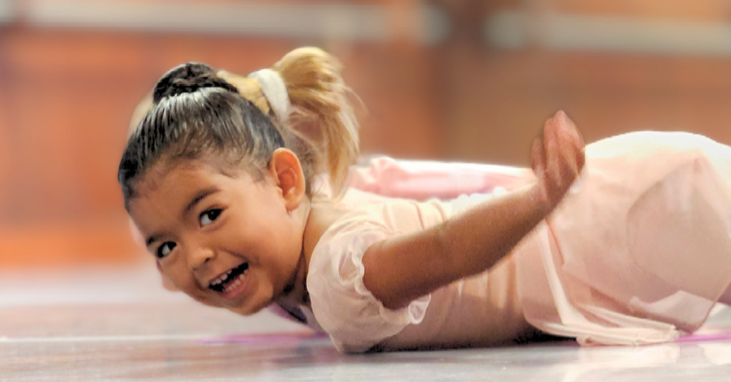 Young preschool dancer in a pink leotard smiling during a Little Stars ballet class at Prince William Dance Academy in Nokesville, VA.