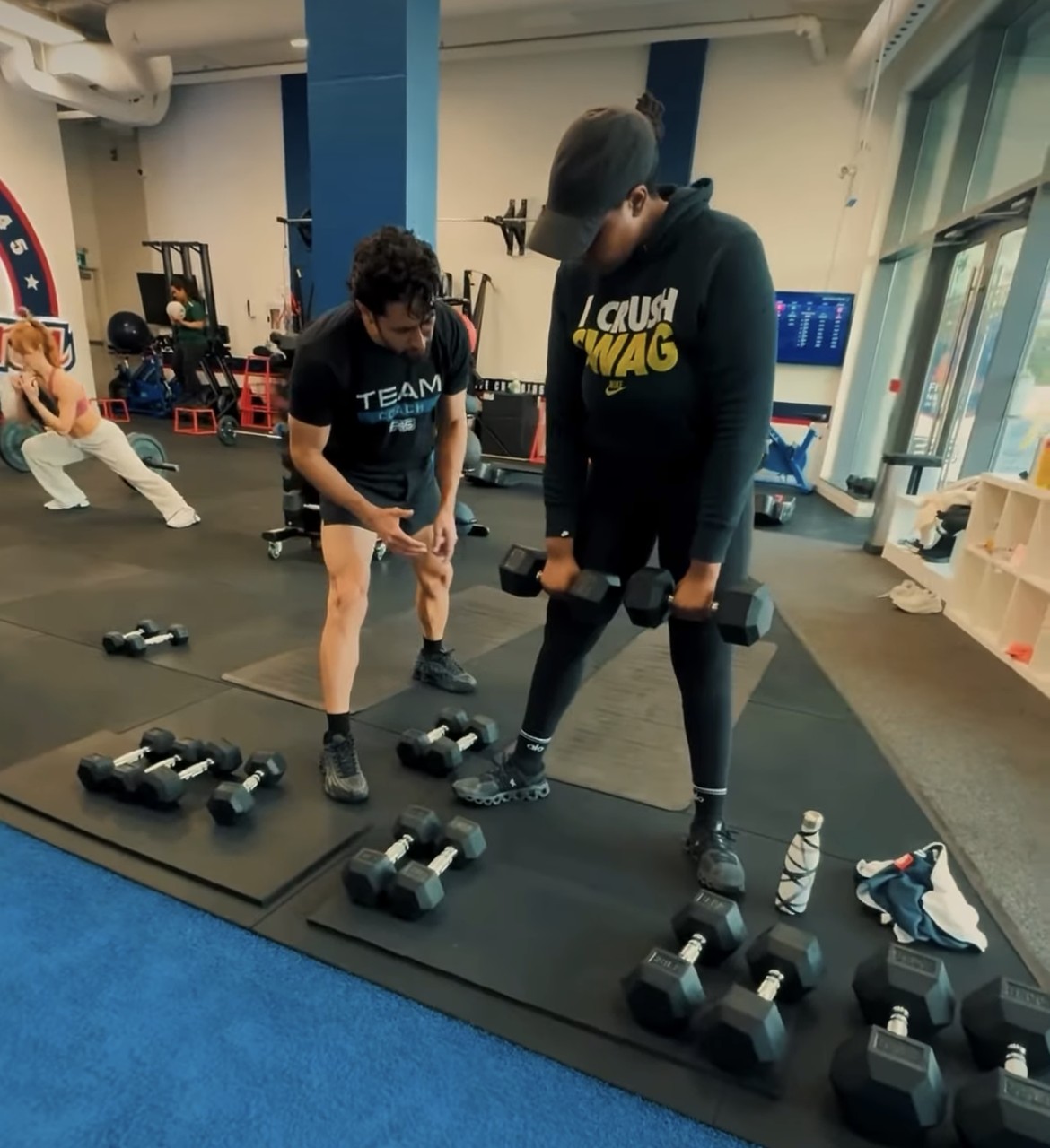 F45 Humber Bay coach helping a member with dumbbell form