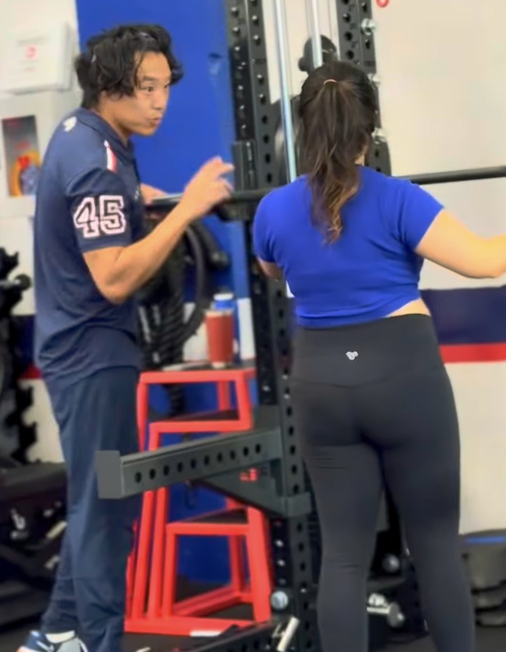 F45 Humber Bay coach guiding a member at the barbell rack