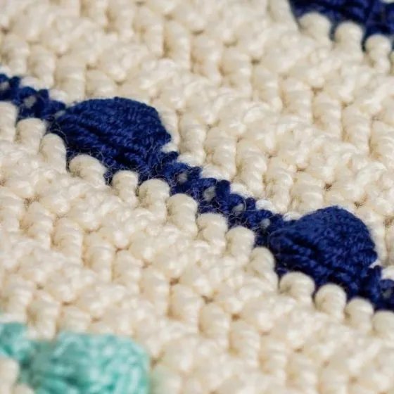 a merino wool and bamboo mix handmade baby blanket in cream with navy blue and aqua bobble stitches a merino wool and bamboo mix handmade baby blanket in cream with navy blue and aqua bobble stitches